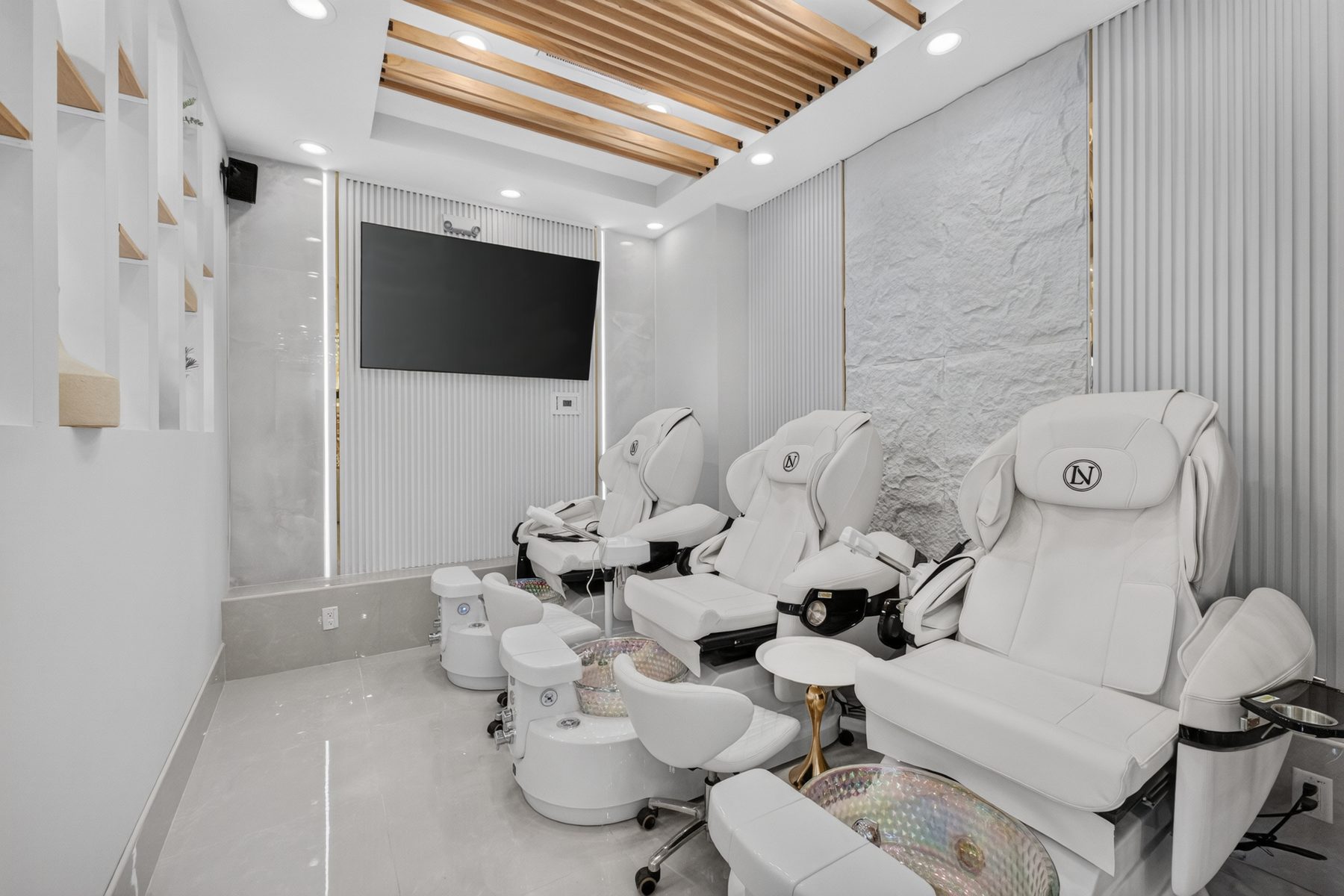 Reclining pedicure chairs against the stone feature wall